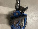 a blue chainsaw sitting on top of a cement floor