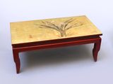 une petite table sur laquelle est posé un tableau, à côté d'un vase