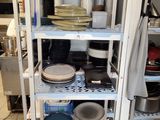 many plates and pans on the shelves in the kitchen