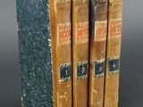 three old books are stacked on top of each other on a table