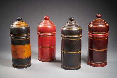 trois bidons rouges et noirs sont alignés sur un fond gris