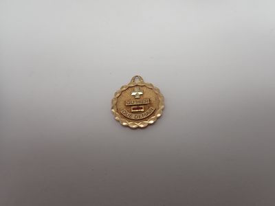 gros plan d'une médaille d'or sur une surface blanche