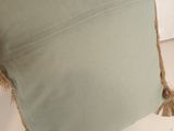 an image of a green pillow with fray edges