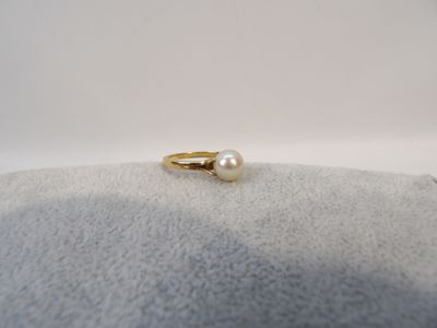 a close up of a ring with a pearl on it