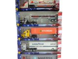 quatre camions miniatures dans une vitrine sur fond blanc