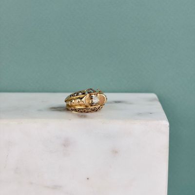 un gros plan d'une bague en or posée sur un bloc de marbre