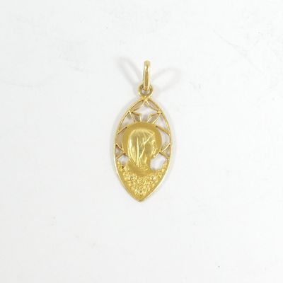 Gros plan sur un pendentif en or orné d'un oiseau