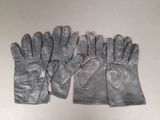 three pairs of leather gloves sitting on top of a table