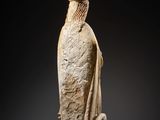 an ancient statue of a woman with a bird on her head