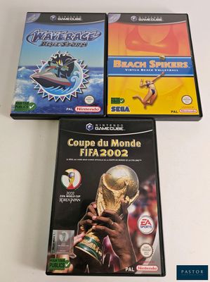 three video games are sitting on a white surface
