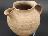 a clay pot with a handle on a stand