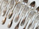 a lot of silver spoons and forks on a white table