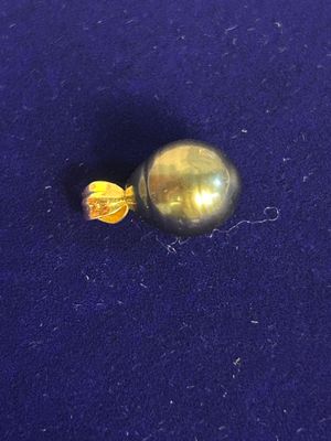 yellow glass bead on a blue cloth with a yellow bead in the middle