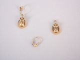 trois paires de boucles d'oreilles en or posées sur une surface blanche, sur fond blanc