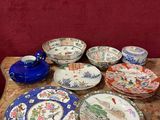 many plates and bowls on a table with a red wall in the background