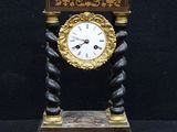 a clock that is sitting on a stand on a black background