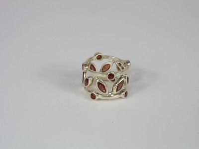 a silver ring with garnets on it on a white surface
