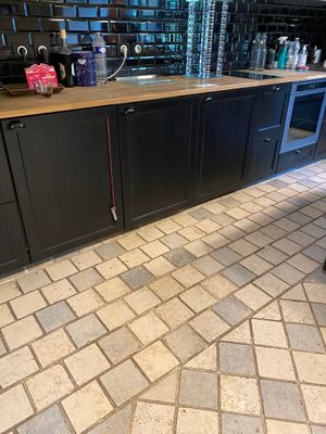 a kitchen with black cabinets and a tile floor