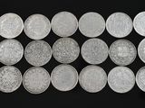 a bunch of silver coins sitting on top of a black surface
