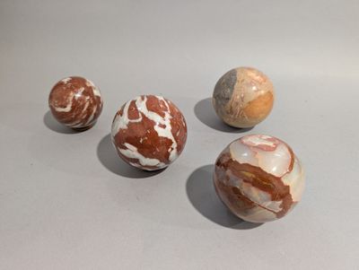 four marble balls sitting on top of a table next to each other