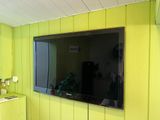 a television mounted on the wall in a yellow room