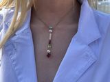 the woman is wearing a white shirt and a gold necklace