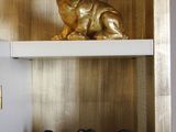 une statue en or représentant un chien, posée sur une étagère