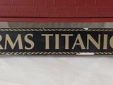 a black and gold sign that says rms titanic on it