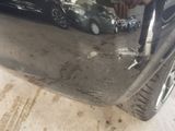 a man that is fixing the bumper of a car