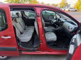 a small red car with its doors open in a parking lot