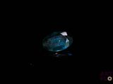 a close up of a blue diamond on a black surface