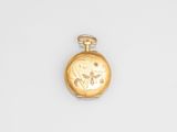 l'image d'une montre de poche en or posée sur une surface blanche