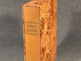an old book sitting on top of a wooden box on a table