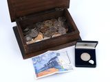 une boîte en bois remplie de pièces et une pièce en argent