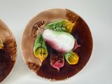 two plates with flowers painted on them sitting on a table