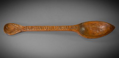 wooden spoon with a carved inscription on it that says, ' the great of the island '