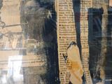 une photo d'un vieux journal sur lequel est posé un morceau de papier déchiré
