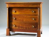 une photo d'une commode en bois posée sur une surface blanche