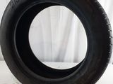 tire on a white surface with a white curtain in the background