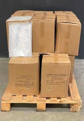 des cartons empilés sur une palette devant un mur noir