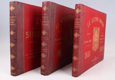 trois livres rouges sont alignés les uns à côté des autres sur une surface blanche