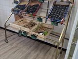 un étalage de fruits et légumes sur un chariot dans un magasin