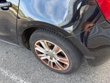a black car parked in a parking lot with its door open