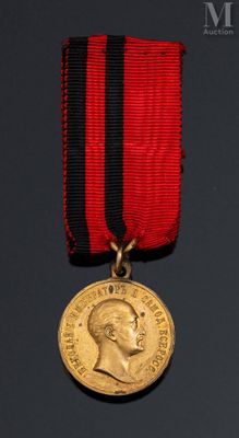 une image représentant une médaille entourée d'un ruban rouge