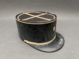 chapeau haut-de-forme noir et doré, orné d'un motif en forme de croix sur le devant