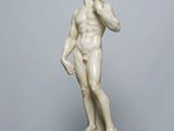 marble statue of a man holding a phone to his ear