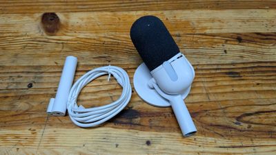 un micro et un chargeur posés sur une table en bois