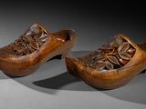 pair of wooden clogs with carved flowers on them
