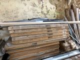 un tas de bois posé par terre près d'un mur