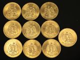 six gold sovereigns are arranged in a circle on a black surface